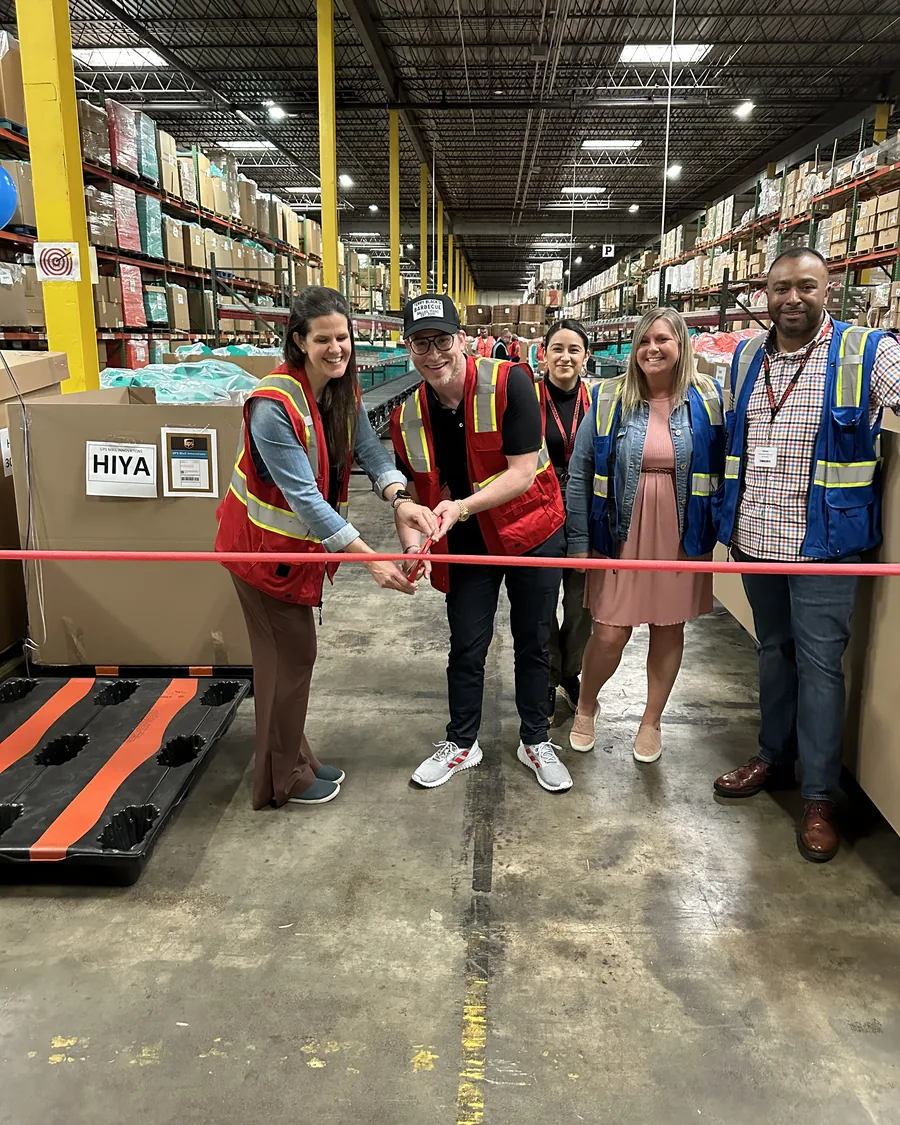 Adam and the team cutting the ribbon on Hiya's upgraded shipping facility